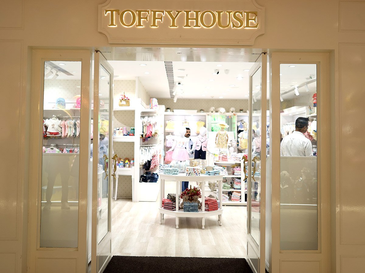 Interior view of the Toffy House store showing racks of children's clothing